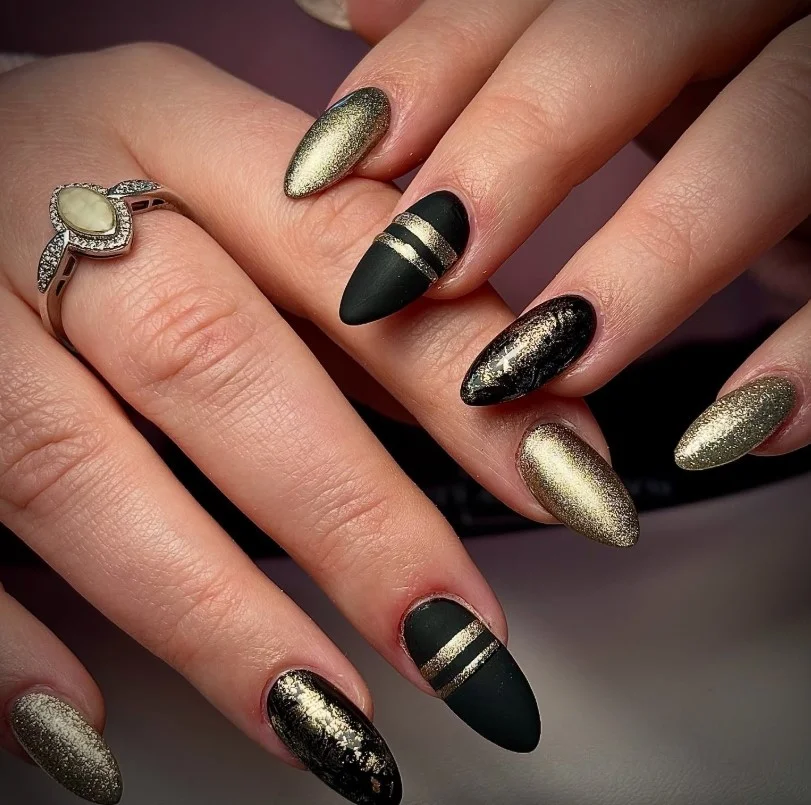 Black almond nails design with gold foil accents luxury elegant nail art inspiration