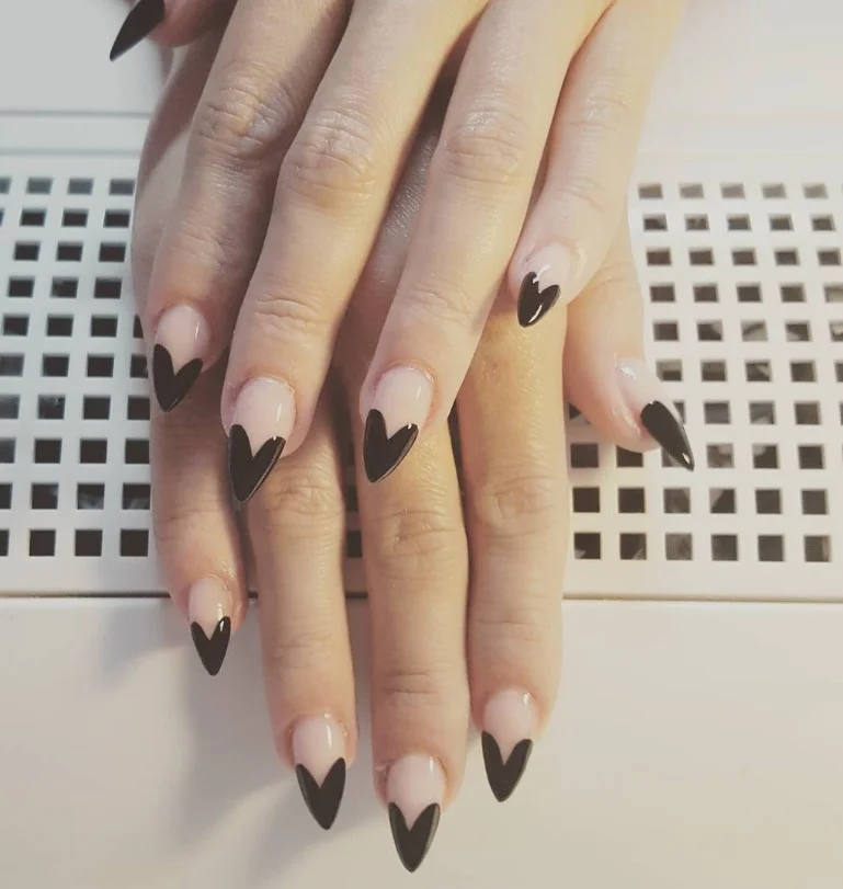 Black almond nails design with heart accents romantic cute nail art inspiration