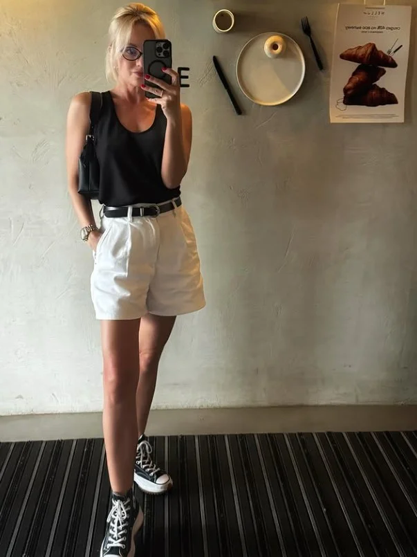 Black fitted tank top styled with tailored shorts for a sleek summer outfit.