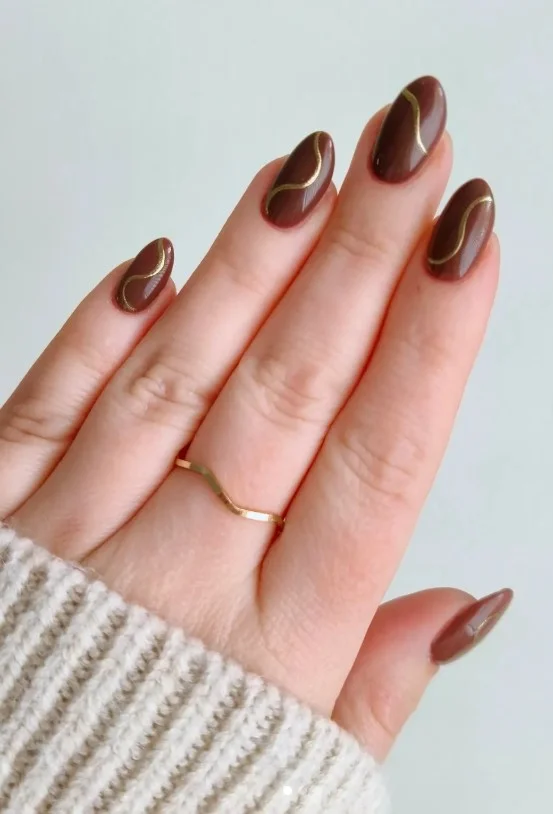 Brown almond nails with gold accent elegant party nail design stylish look