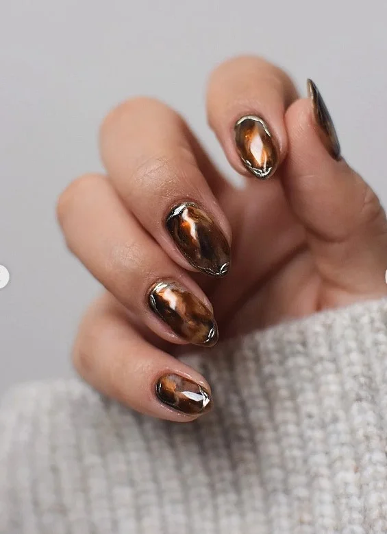 Artistic brown marble almond nails with natural stone effect design.