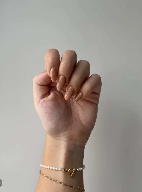 Light brown almond nails in a glossy honey latte shade with a soft elegant finish.