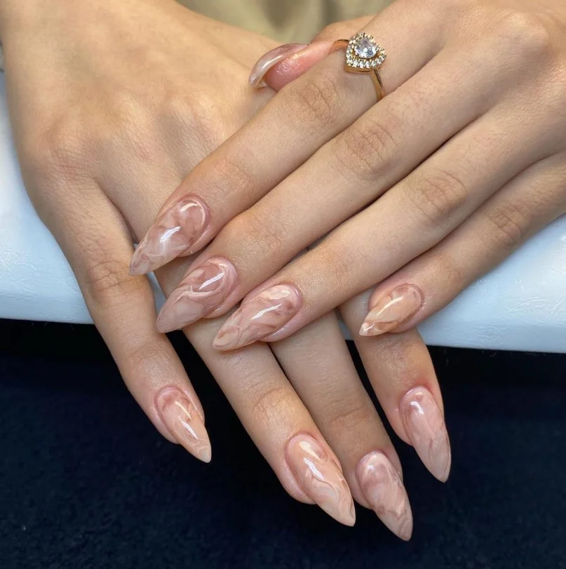 Light brown marble almond nails featuring soft swirls and luxury nail art.
