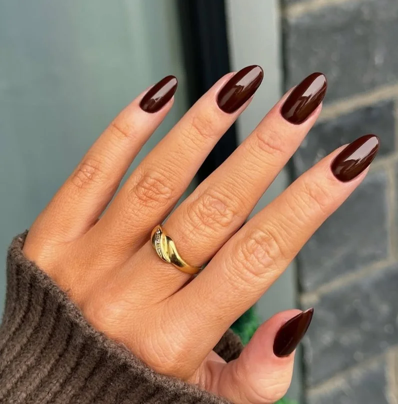 Deep dark brown almond nails almost black with sleek finish.