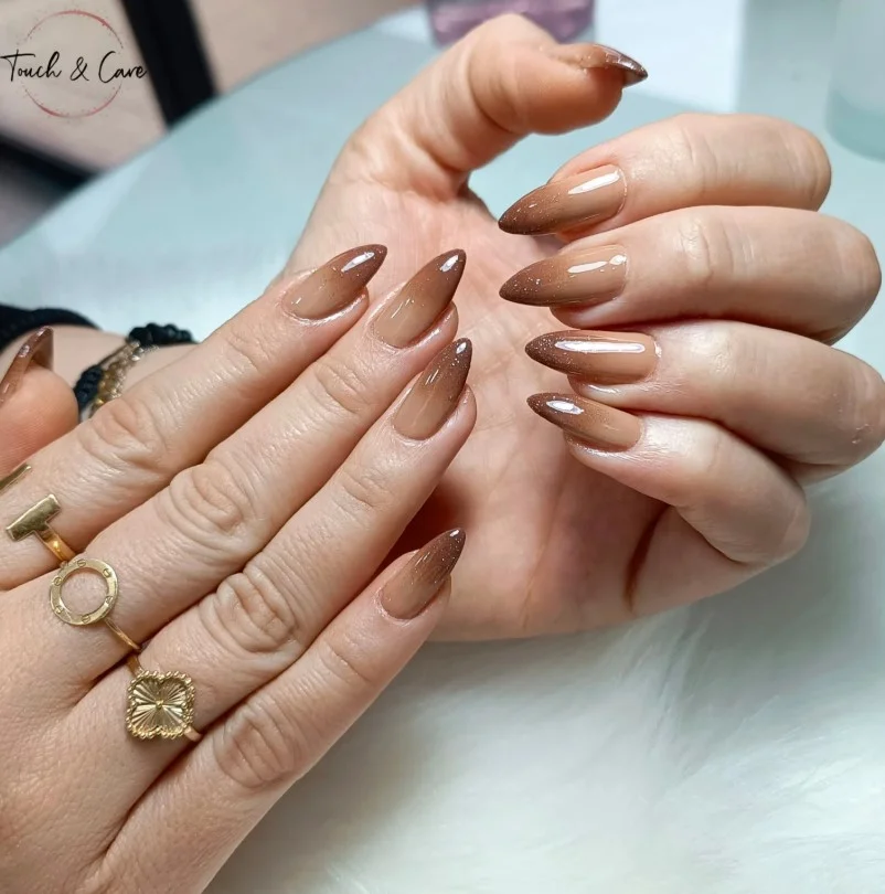 Soft ombre almond nails blending light and medium brown shades seamlessly.