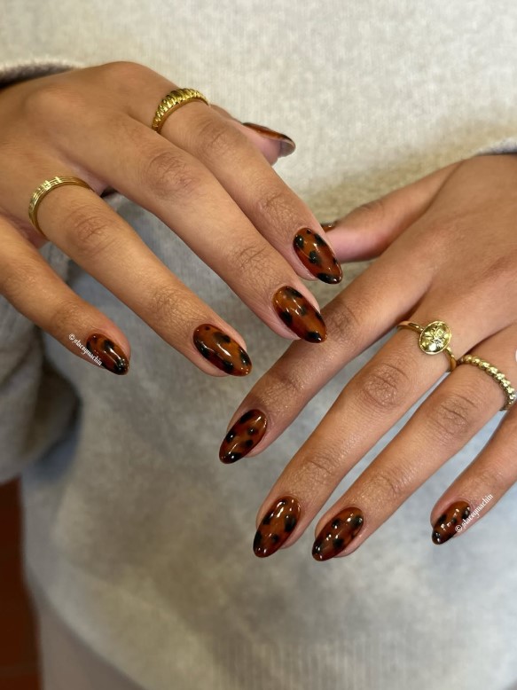 Almond nails with tortoiseshell accents and warm light brown color palette.