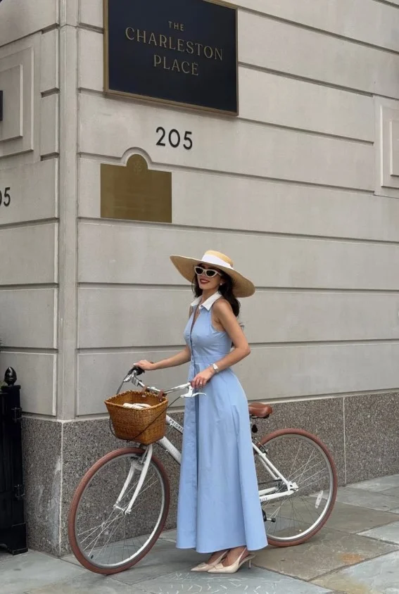 Baby blue dress outfit with a straw hat and flat sandals for a sunny vacation outfit.