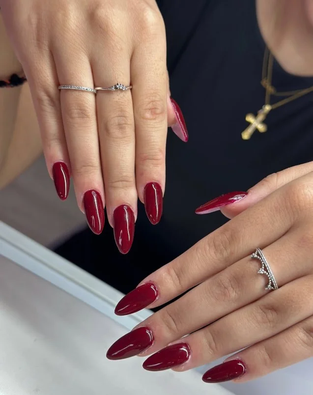 Cherry red nail polish creating contrast on pale skin