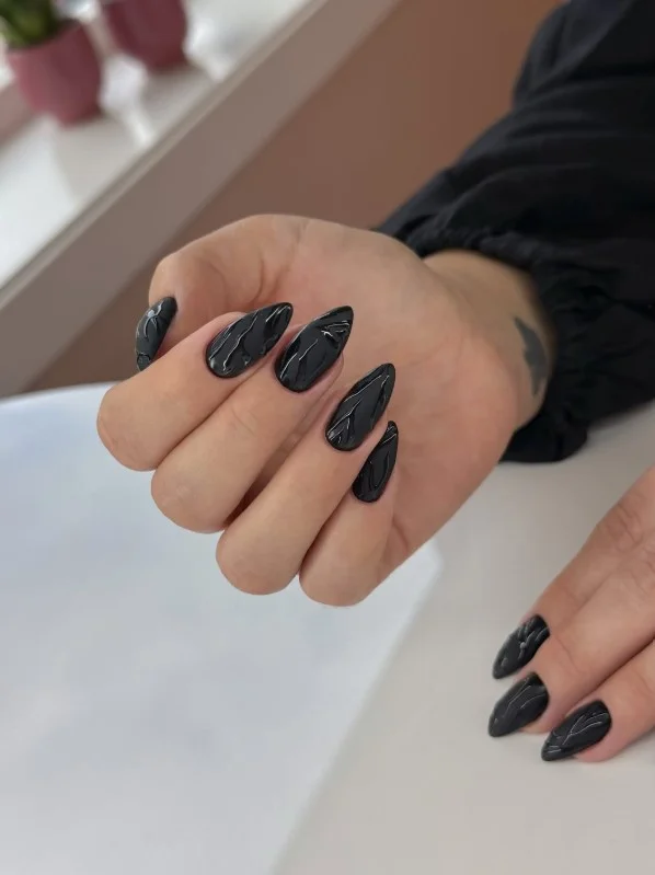Glossy black nails creating a timeless manicure for pale skin