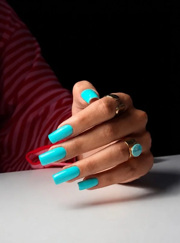 Bright turquoise nail polish for glowing summer tan skin