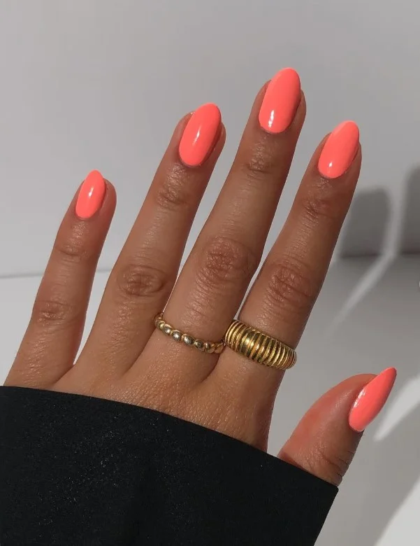 Coral nail polish enhancing a healthy glow on tan skin