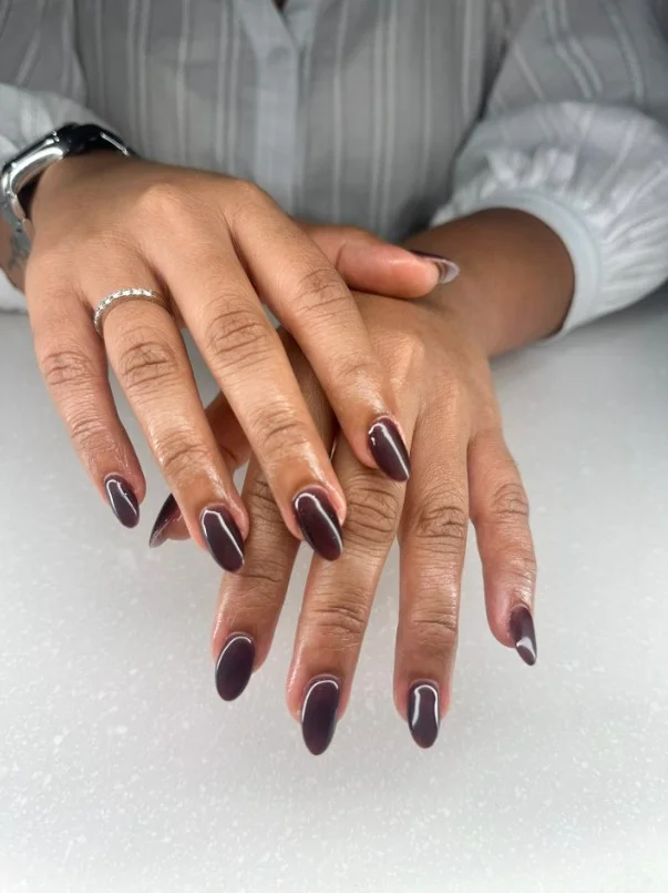 Deep plum manicure creating an elegant look for tan skin