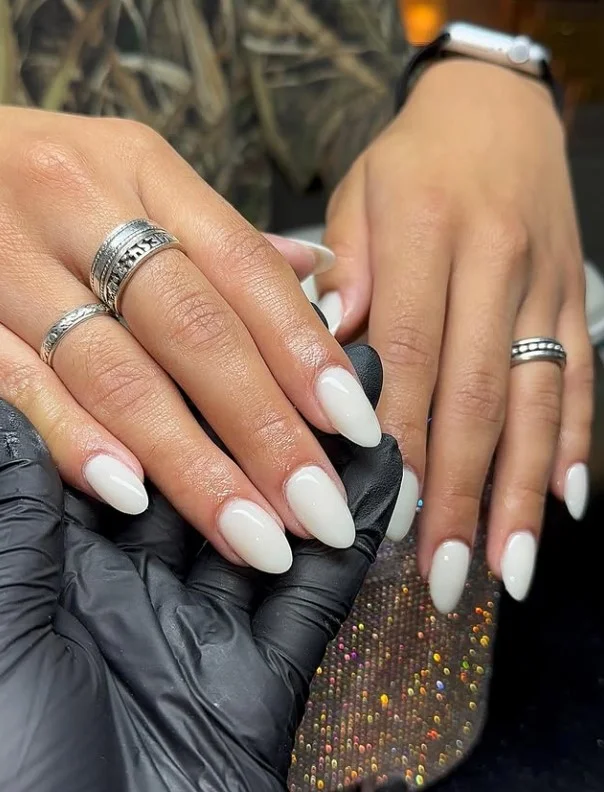 Milky white nail polish creating a fresh manicure on tan skin