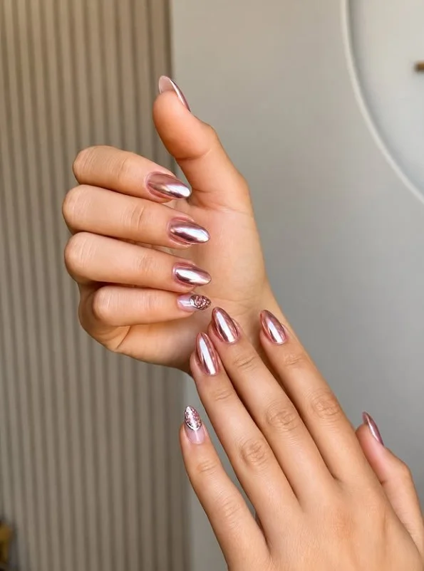 Rose gold metallic nails with a soft shimmer on tan skin