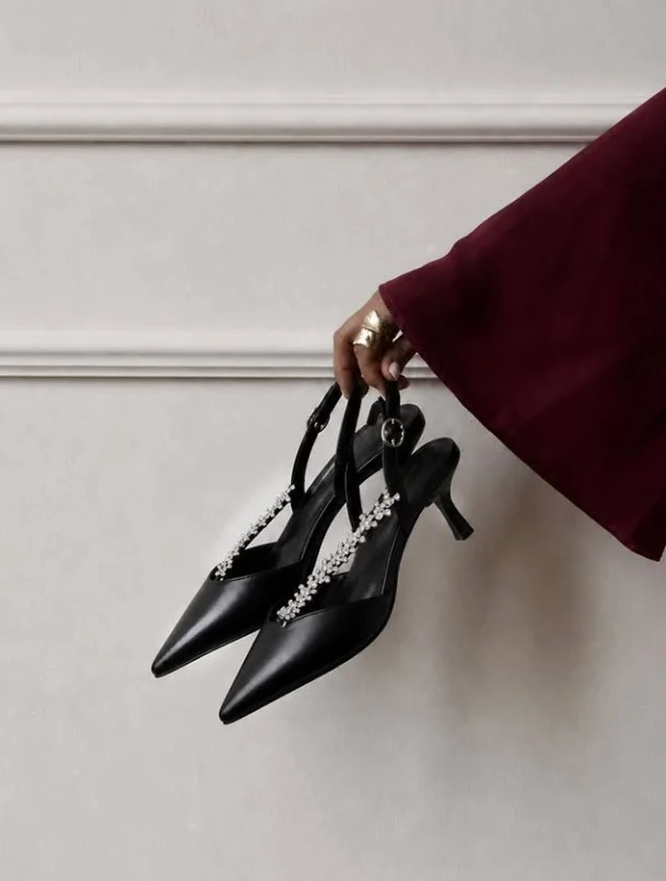 Classic red cocktail dress matched with black suede pumps for a polished and timeless evening look.