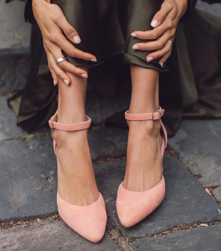 Blush heels completing a romantic black dress outfit for a special event.