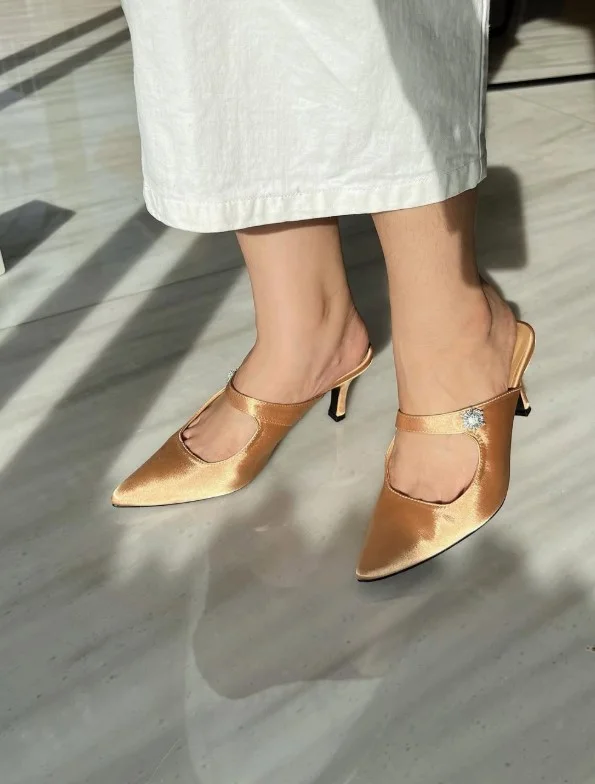 White evening dress paired with bronze metallic heels for a warm and sophisticated style.