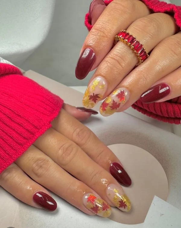 Burgundy fall nail designs featuring delicate autumn leaf nail art with warm seasonal colors.