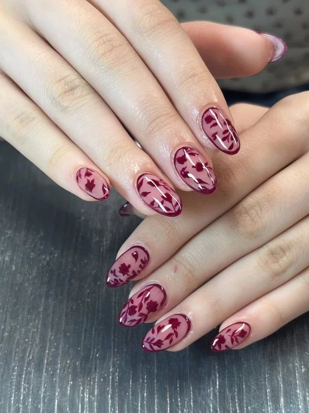 Burgundy fall nail designs with delicate floral nail art for a soft feminine autumn manicure.