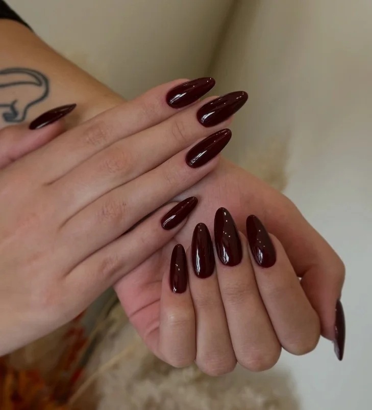 Burgundy nails adding rich contrast to a deep purple dress.