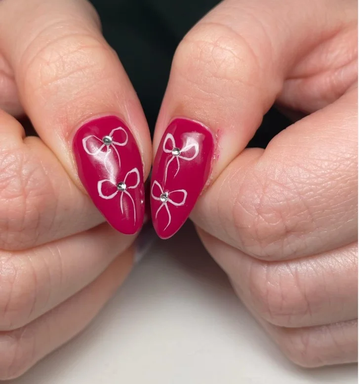 Burgundy fall nail designs decorated with elegant velvet bow details for a chic seasonal manicure.