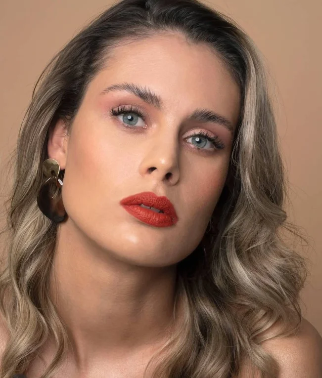 Burnt orange lipstick that complements warm olive skin with rich seasonal color.