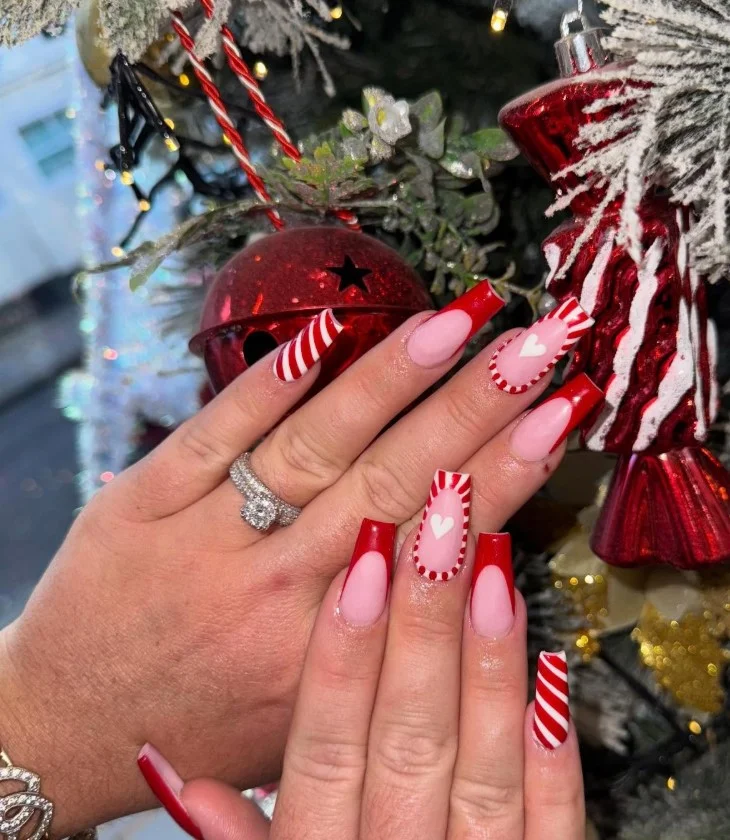 Cute Christmas nail designs with thin red and white candy cane stripes on glossy almond-shaped nails.