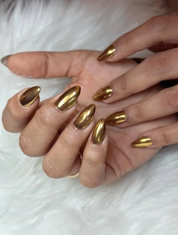 Champagne gold nails styled with a green dress for weddings and celebrations.