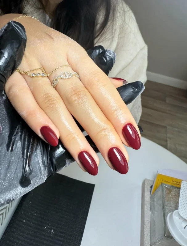 Classic cherry red manicure complementing a green dress for a timeless look.