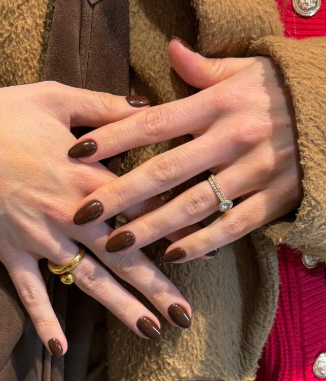 Chocolate brown nails complementing a dark purple evening dress.