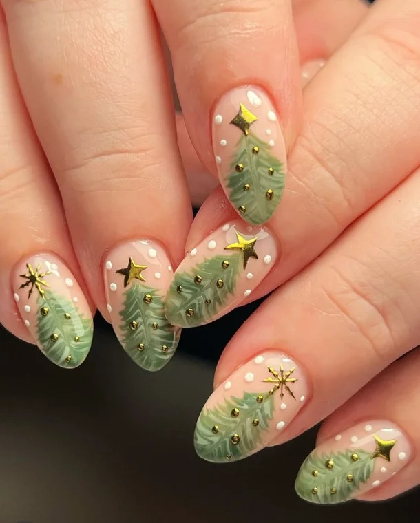 Cute Christmas nail designs featuring miniature evergreen trees topped with tiny gold stars on nude nails.