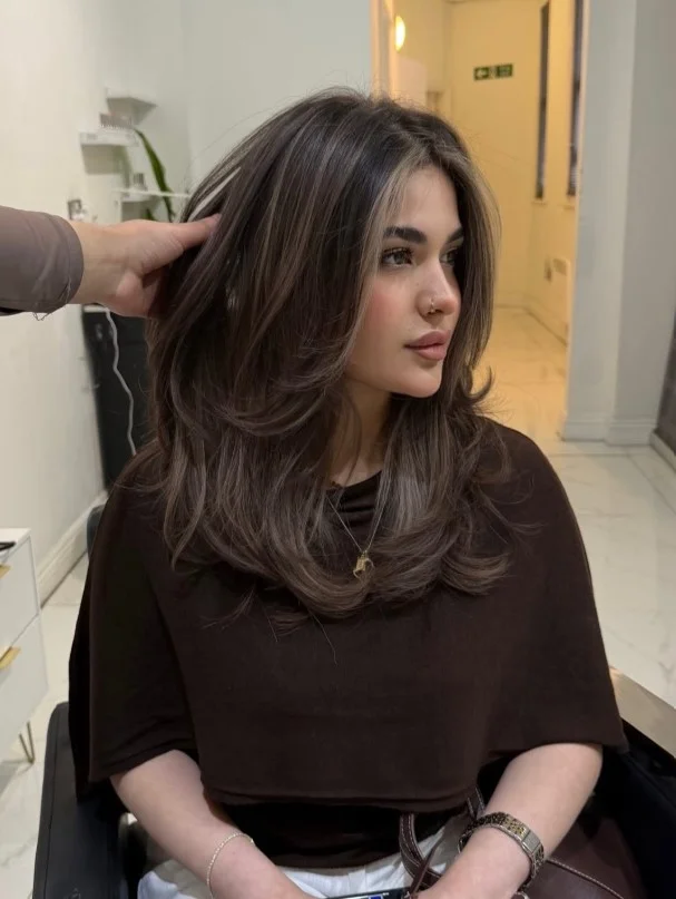 Cool ash brown hair with smoky tones complementing fair skin.