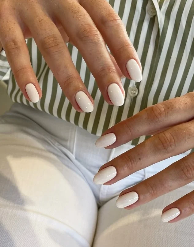 Cream manicure paired with a sage green dress for a fresh and elegant outfit.