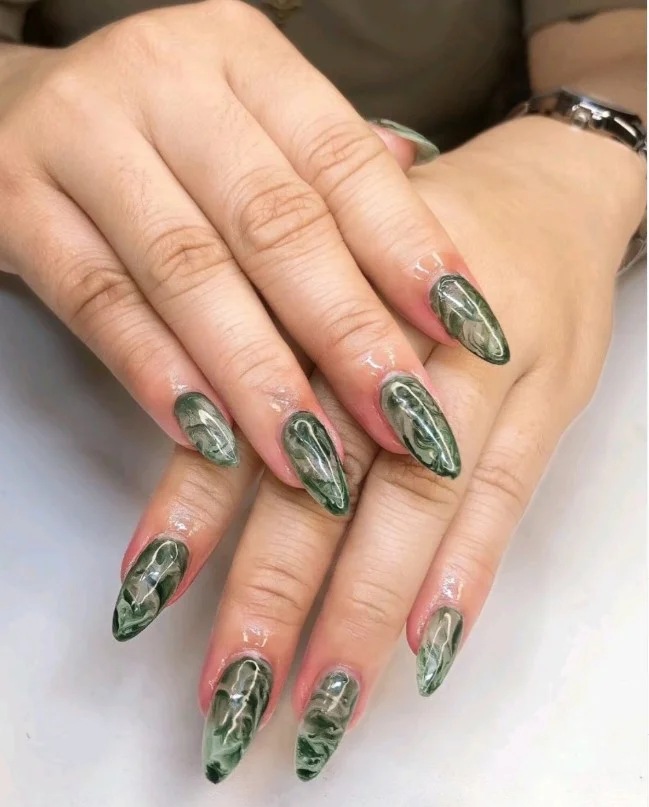 Long nails featuring soft marble accent art with delicate white and neutral stone-inspired details.