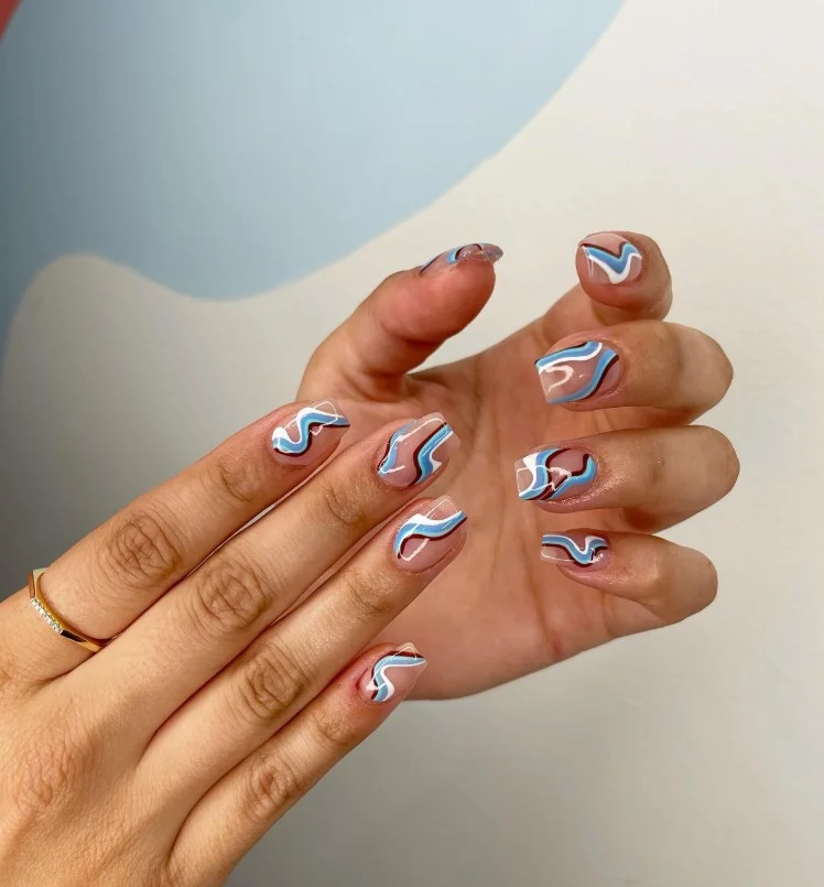 Long square nails decorated with elegant minimalist swirl nail art on a neutral glossy base.