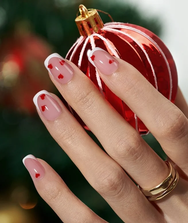 Cute short square nail designs featuring tiny white heart details on a soft glossy nude base.