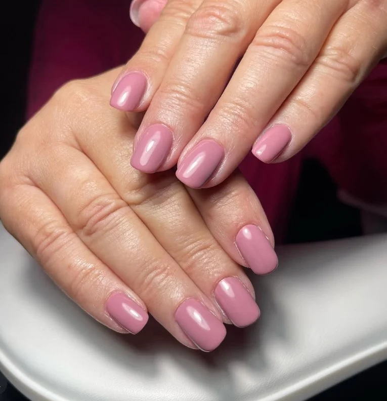 Dusty mauve manicure paired with a green dress for a sophisticated look.