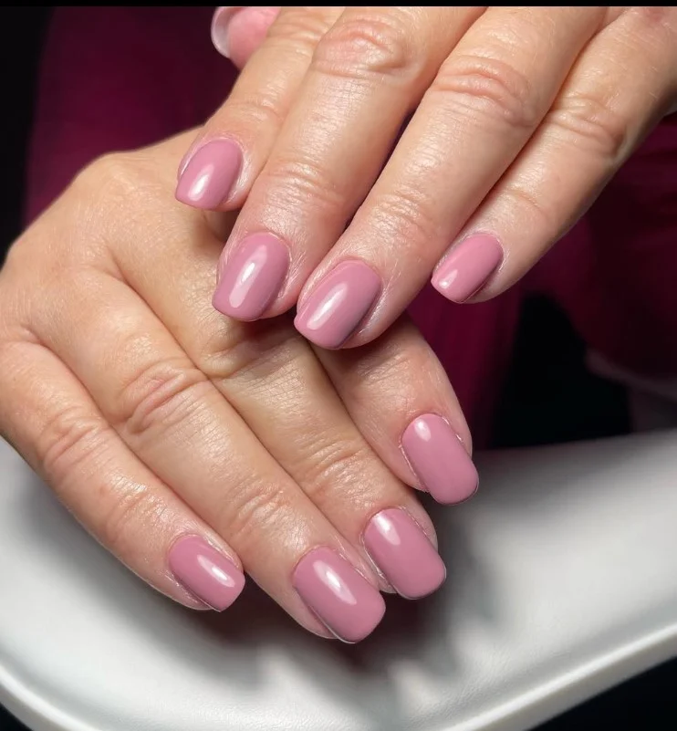 Dusty mauve nails creating a soft, elegant look with a purple dress.