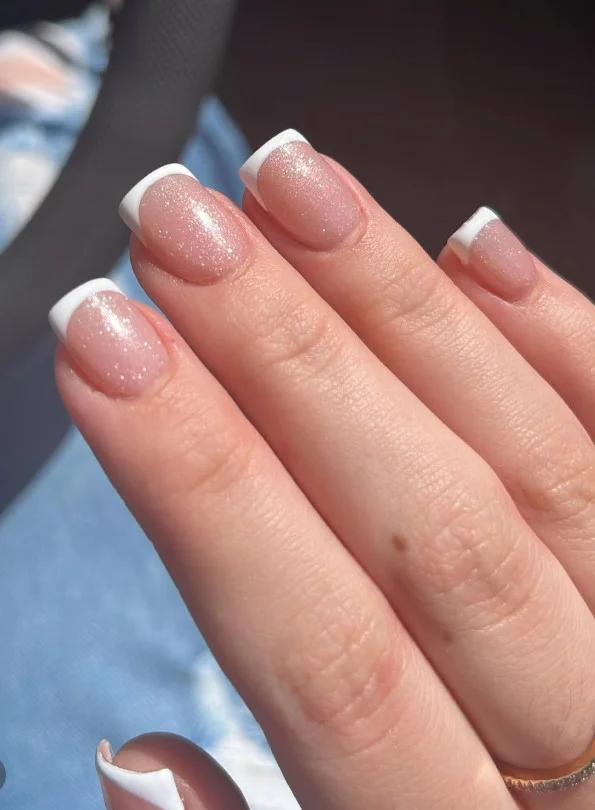 Glitter nude nails bringing soft sparkle to a purple party dress.