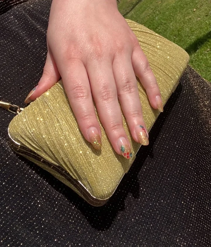 Cute Christmas nail designs with elegant fine gold glitter over a festive holiday manicure.