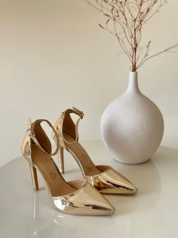 White satin dress paired with gold strappy heels for a glamorous evening look.