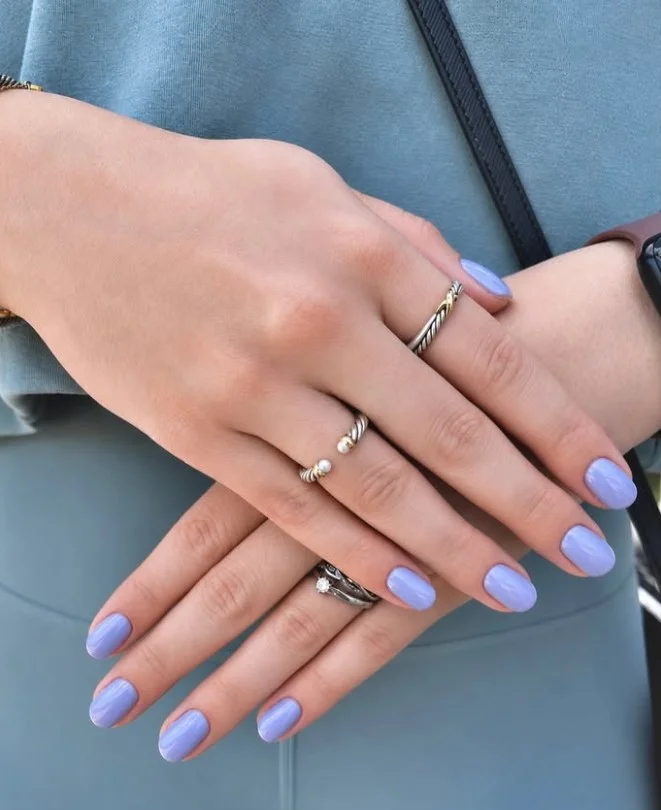 Pale lavender manicure adding soft contrast to a green dress.