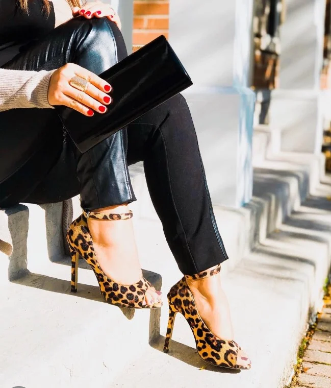Leopard print heels adding personality to a classic black dress.
