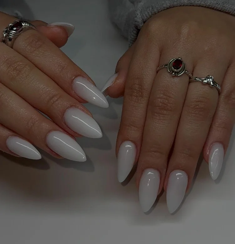 Milky white manicure paired with a navy blue dress for a clean and elegant look.
