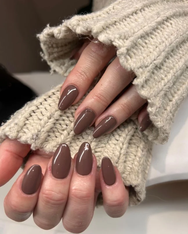 Mocha brown nails paired with an olive green dress for autumn fashion.