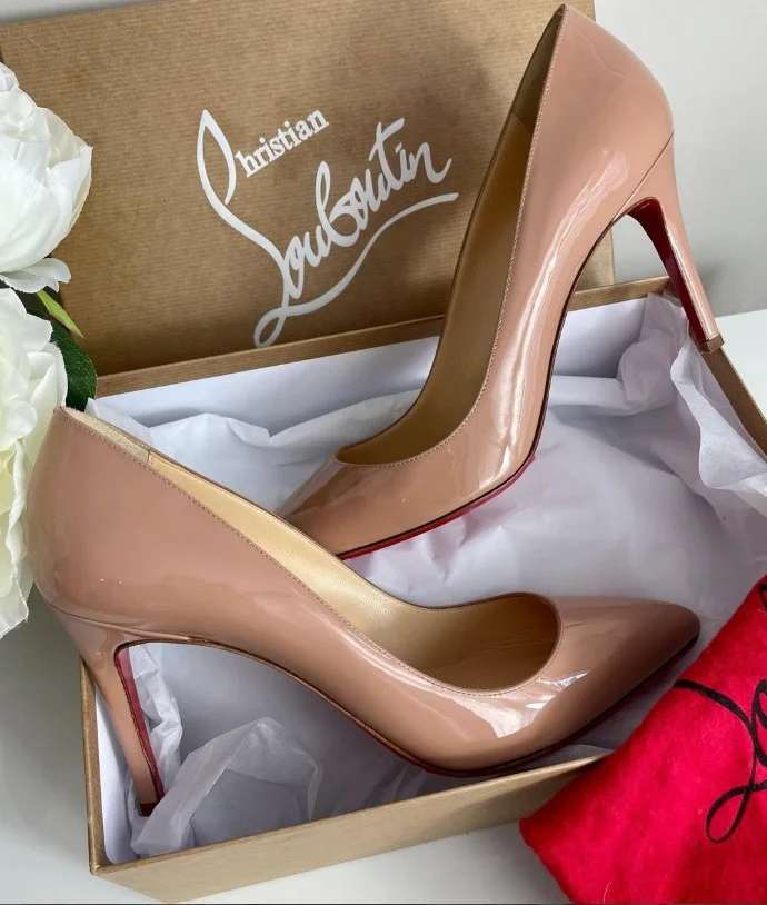 Woman wearing a fitted red midi dress with elegant nude pointed-toe heels for a timeless wedding guest outfit.