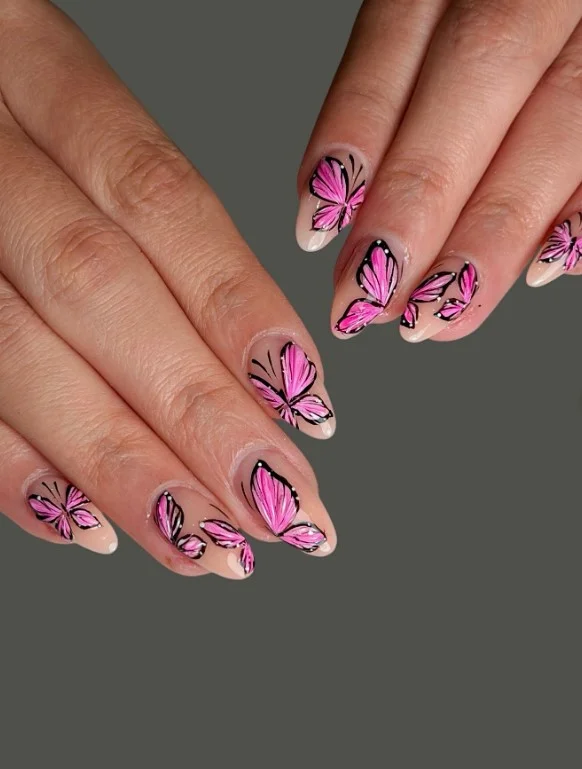 Pink butterfly nail designs with delicate butterfly artwork on a soft glossy pink manicure.