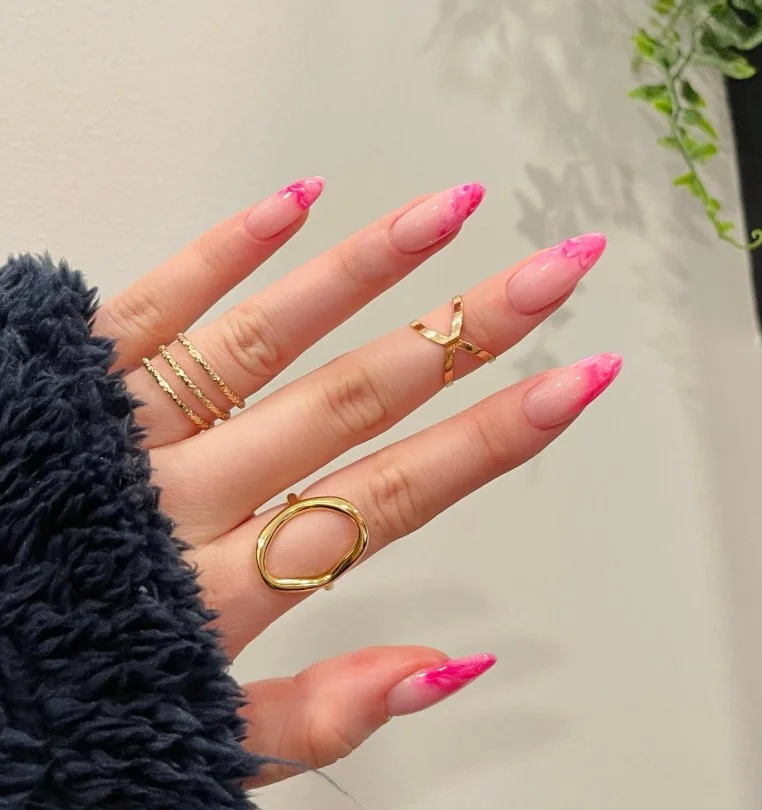 Pink marble nail designs featuring soft white stone-inspired veining on elegant glossy nails.