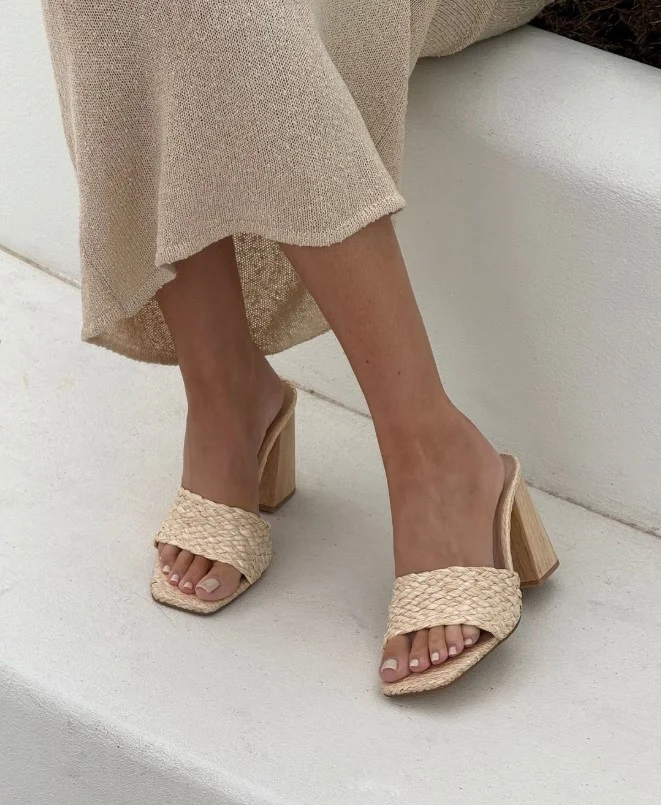 Lightweight white summer dress styled with raffia heels for a relaxed vacation outfit.