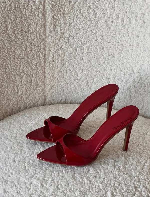 Stylish monochromatic outfit featuring a red dress paired with slightly darker red high heels for a modern, coordinated look.